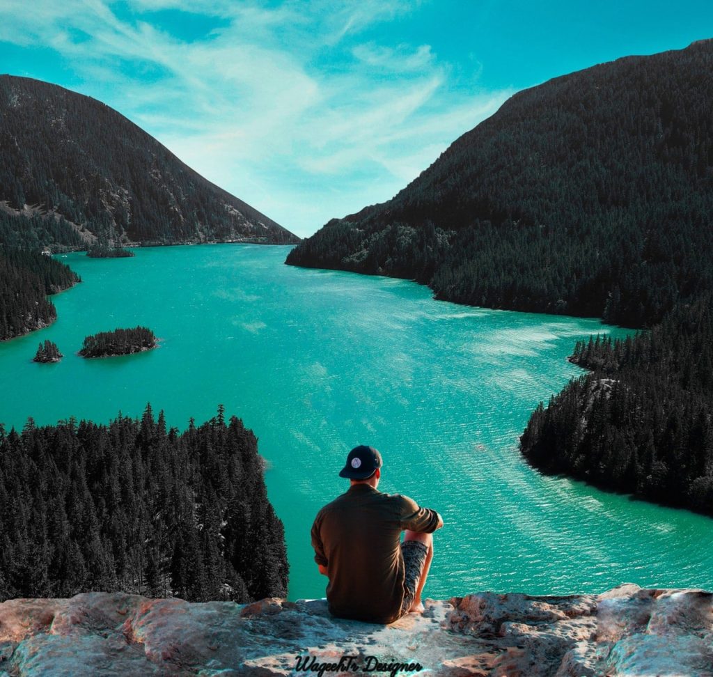 Man Thinking of Men's Issues While Planning Future Overlooking Lake and Mountains Man Thinking of Men's Issues While Planning Future Overlooking Lake and Mountains