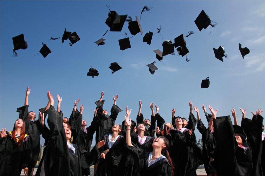 College students graduating and throwing caps in the air